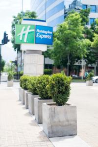 a green street sign sitting on the side of a street at Holiday Inn Express Santiago Las Condes, an IHG Hotel in Santiago
