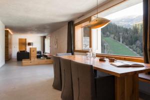 a dining room with a table and a large window at rocksresort in Laax