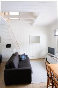 a living room with a couch and a staircase at Lucky Ranch cabin 4 in Pyhätunturi