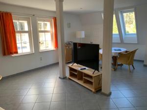 a living room with a tv and a dining room table at Ferienwohnungen im Landhaus Wiesenbad in Thermalbad Wiesenbad