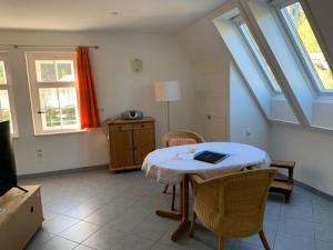 Una sala de estar con una mesa con una computadora portátil encima. en Ferienwohnungen im Landhaus Wiesenbad, en Thermalbad Wiesenbad
