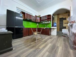 a kitchen with black appliances and a green wall at CENTRAL HOME in Pleiku