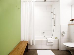 a bathroom with a shower and a toilet and a sink at Hotel-Landgasthof KREUZ in Bad Waldsee +33 photos