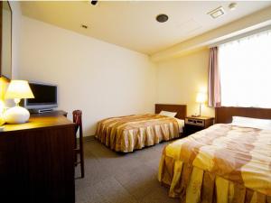 um quarto de hotel com duas camas e uma televisão de ecrã plano em Hotel Pao em Hiroshima