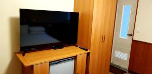 a flat screen tv sitting on top of a wooden stand at New May Flower Hotel in Taipei