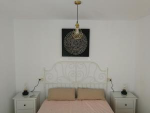 a bedroom with a white bed and a pendant light at CASA SAN ANTÓN in Arcos de la Frontera