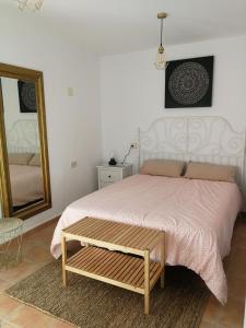 a bedroom with a bed and a mirror and a table at CASA SAN ANTÓN in Arcos de la Frontera