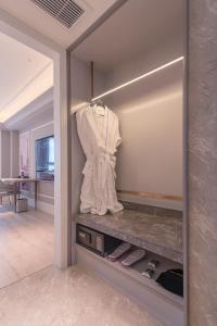 a dressing room with a mirror with a robe and shoes at Mercure Hotel Hangzhou East Railway Station in Hangzhou