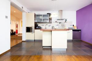 a kitchen with white cabinets and a purple wall at Apartment Warsaw City Center in Warsaw