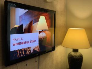 a flat screen tv hanging on a wall with a lamp at Hotel Residence Agnes in Prague