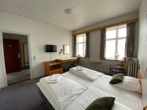 LøgstørにあるLøgstør Badehotel - Hotel du Nordのベッドルーム1室(ベッド2台、デスク、窓付)