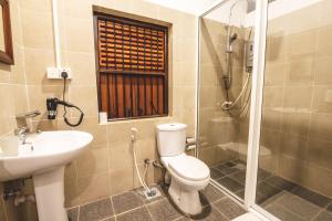 a bathroom with a toilet and a sink and a shower at Thambu Illam in Jaffna