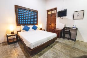 a bedroom with a bed and a television in it at Thambu Illam in Jaffna