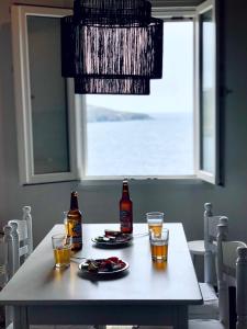 Una mesa con dos botellas y vasos. en En Plo en Agios Romanos