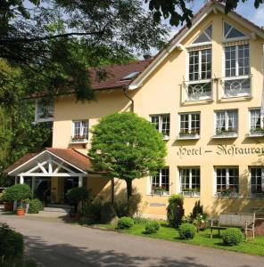 a large yellow building with a tree in front of it at Hotel Mühle in Binzen