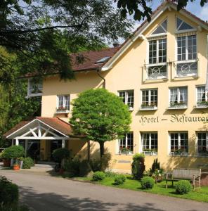 ein großes gelbes Gebäude mit einem Baum davor in der Unterkunft Hotel Mühle in Binzen