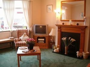 een woonkamer met een open haard en een televisie bij The Adelphi in Paignton