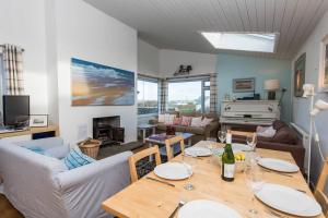 a living room with a table with wine glasses on it at TARIAN HAF-3 BED-SEA VIEW BUNGALOW-TREARDDUR BAY in Trearddur