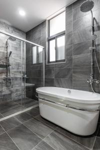 a bathroom with a bath tub and a shower at Meets Anping in Tainan