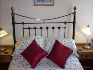 a bedroom with a bed with two red pillows at The Adelphi in Paignton