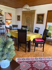 uma sala de jantar com uma mesa amarela e cadeiras em Helga Vendégház em Budaörs