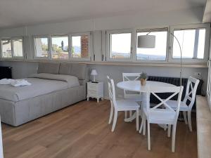 1 dormitorio con 1 cama, mesa y sillas en Panoramic Suite, en Cavaion Veronese