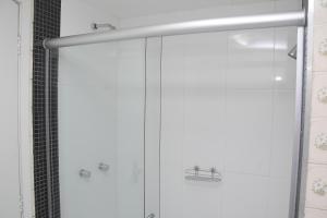 a shower with a glass door in a bathroom at Ikeda Hoteis in Brasilia