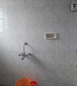 a bathroom with a shower head on a tiled wall at Vamoose Laxmi Hill Resort in Satara
