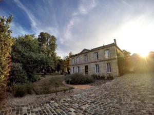 an old house on a cobblestone road in front of a building at Château Ormes de Pez in Saint-Estèphe