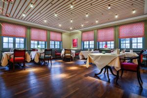 une salle à manger avec tables, chaises et fenêtres dans l'établissement Hotel Stadt Hamburg, à Westerland