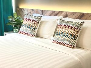 a white bed with two pillows on top of it at G5 HOTEL AND SERVICED APARTMENT in Johor Bahru