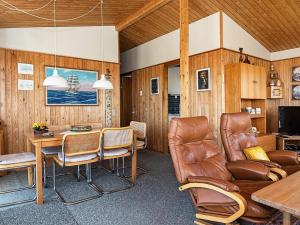 een woonkamer met een tafel en lederen stoelen bij 5 person holiday home in Ringk bing in Søndervig