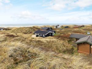 um grupo de casas numa colina junto ao oceano em 6 person holiday home in Hirtshals em Hirtshals