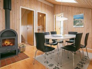 a dining room with a table and a fireplace at 6 person holiday home in Hj rring in Lønstrup