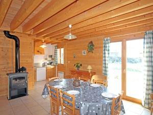 ein Esszimmer mit einem Tisch und einem Herd in der Unterkunft Lovely chalet in Vosges with shared pool in Zhezdi