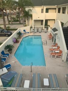a large swimming pool with chairs and a building at Bahama Breeze #2 Sea Dancer Condos in South Padre Island