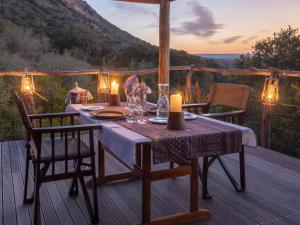 a wooden deck with a table with candles on it at HillsNek Safari Camp – Amakhala Game Reserve in Amakhala Game Reserve
