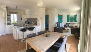 a kitchen and living room with a wooden table and chairs at Villa Esterel Plage in Saint-Raphaël