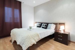 Un dormitorio con una cama grande con almohadas. en Apartamentos Day Madrid SAN ANTONIO Centro Gran Via Sol Malasaña, en Madrid