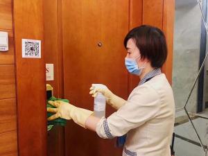a woman wearing a mask and gloves holding a bottle at Guangzhou Hakka Apartment Beijing Road in Guangzhou