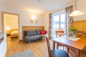 salon z kanapą i stołem jadalnym w obiekcie Appartements Sonnrain w mieście Flachau