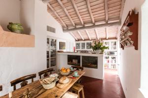 a large kitchen with a wooden table and chairs at Casa do Xão in Serpa