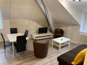 een woonkamer met tafels en stoelen en een trap bij Rue de la banque centre ville Rodez in Rodez