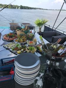 einen Tisch mit Teller mit Speisen auf einem Boot in der Unterkunft Hausboot DeLuxe in Berlin