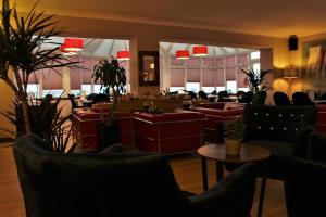 a waiting room with couches and tables and chairs at Argyll Hotel in Bellochantuy