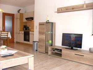 ein Wohnzimmer mit einem Flachbild-TV auf einem Entertainment-Center in der Unterkunft Haus Gertrud in Carolinensiel
