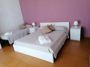 a bedroom with two beds and a purple wall at Antonella's House in Vasto
