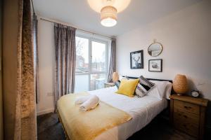 a bedroom with a large bed and a window at Air Host and Stay - Apartment 5 Broadhurst Court sleeps 6 minutes from town centre in Stockport