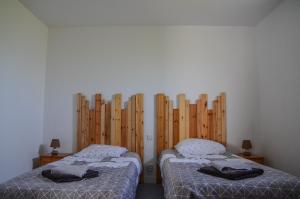 2 camas en una habitación con paredes de madera en Maison proche de la mer, Normandie, en Surville