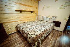 スワエトホルスクにあるFamily Hotel Shaletの木製の壁のドミトリールームのベッド1台分です。